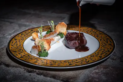 Das Steak mit letzten Verfeinerungen am Tisch 